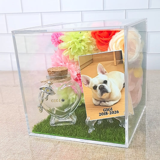 Personalized 3D pet memorial shadow box with custom pet photo, floral decorations, faux grass base, and heart-shaped fur keepsake bottle.