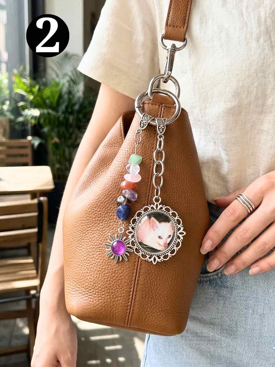 Personalized pet photo charm attached to a handbag for everyday carrying.