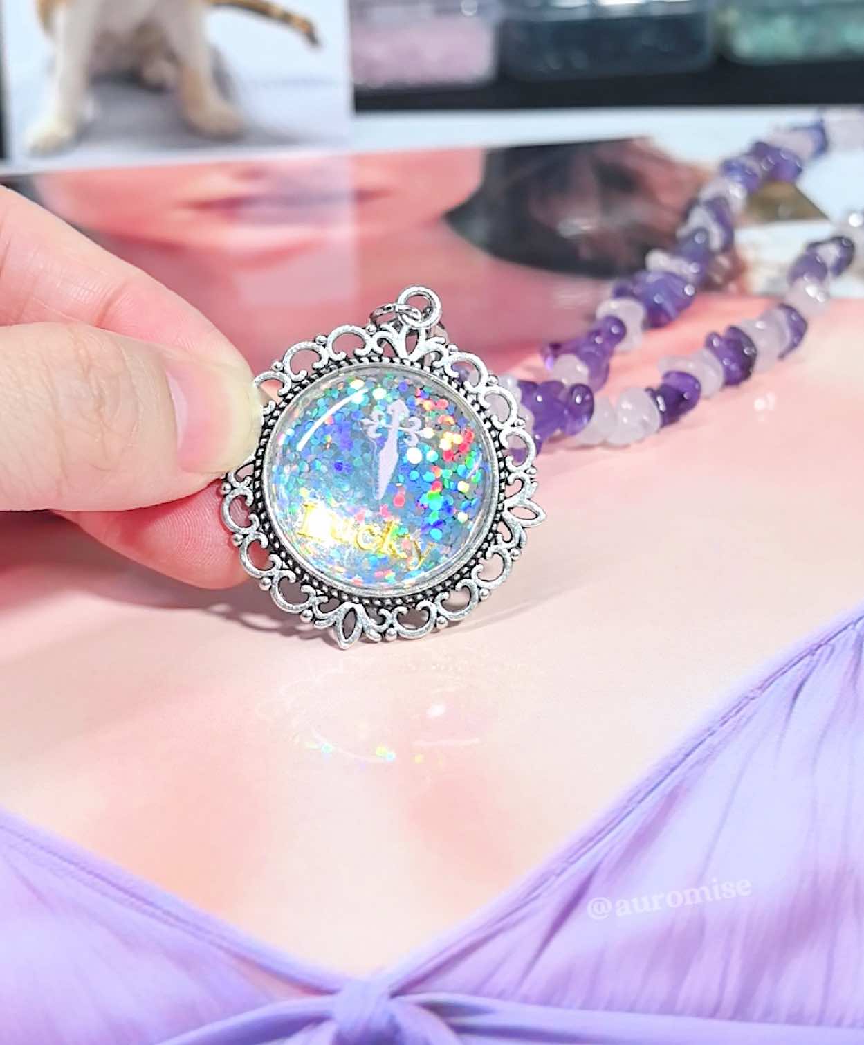 Close up of a personalized pet loss sympathy pendant showing a custom name Lucky on a holographic glitter background.